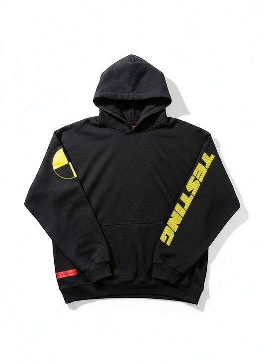 Verified Vault HUMAN MADE x A$AP Rocky black cotton hoodie with yellow "TESTING" graphic on sleeve and crash test dummy logo.